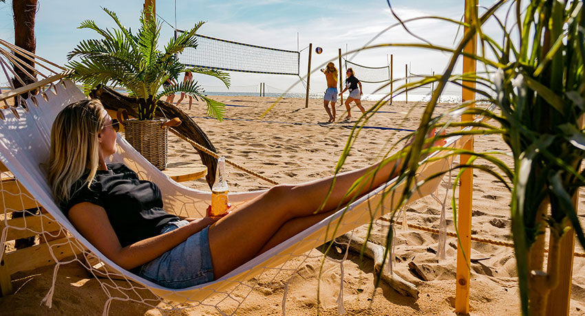 Mädchen liegt in einer Hängematte am Strand