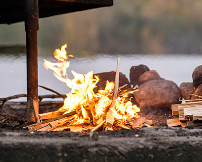 Grillplats där en eld brinner vid en sjö i Halmstad