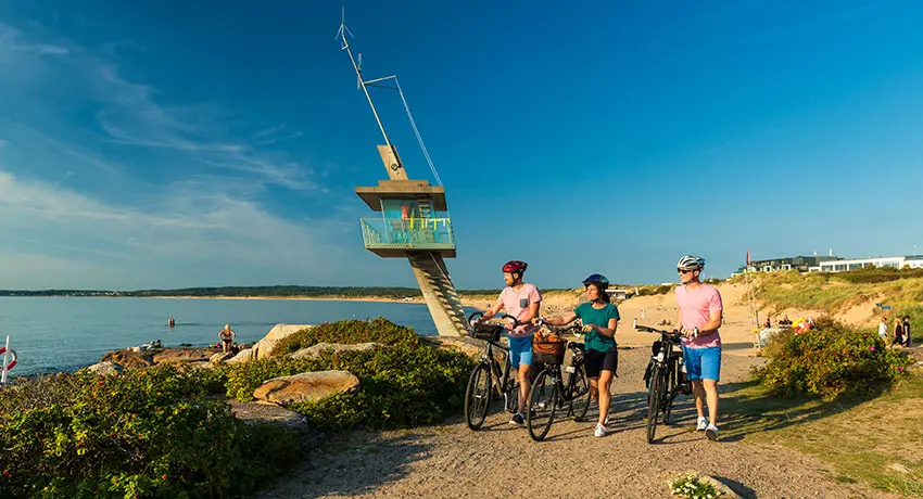 Friends are out cycling by the lifeguard tower in Tylösand