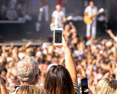 Person holding up mobile udner a concert outdoors