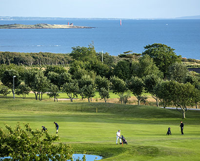 Golfspelare på Ringenäs golfklubb med utsikt över havet