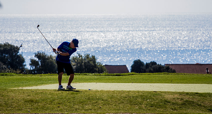 Golfspiller med hav som baggrund