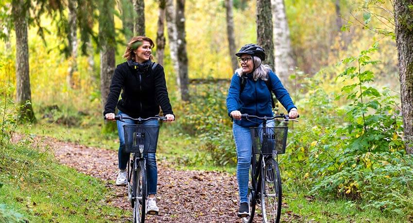 To personer cykler langs Hylteleden i skoven