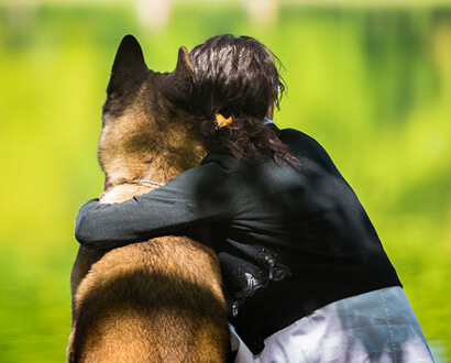 Person kramar om en hund