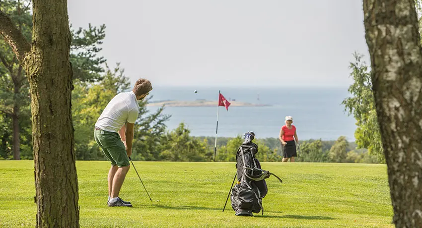 Golfspelare på Ringenäs golfklubb med vy över havet