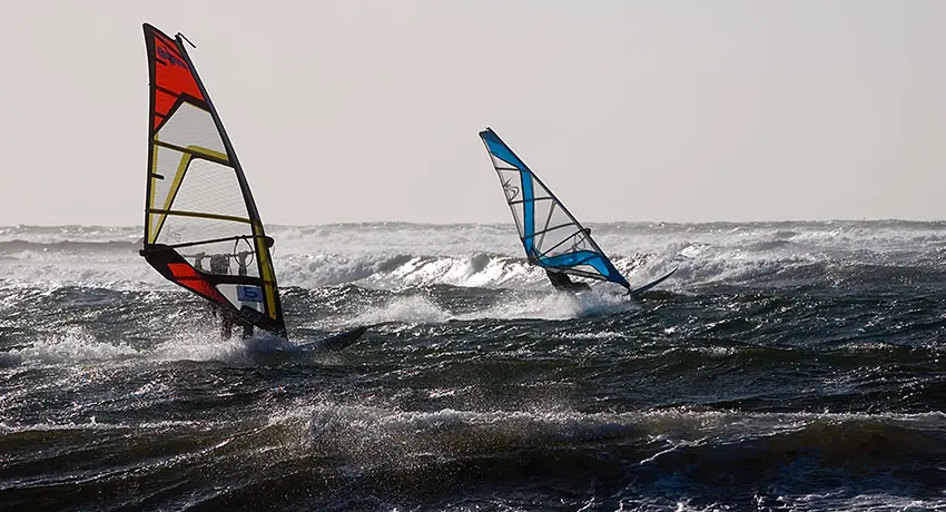 Två vindsurfare ute på havet