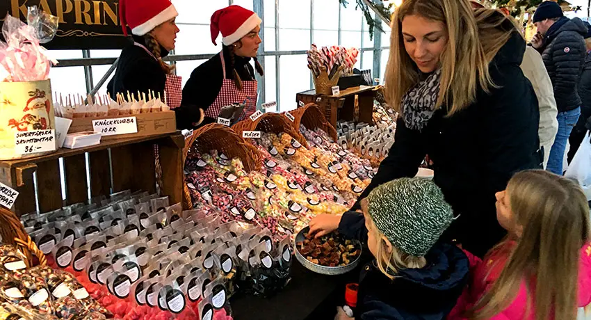 Familj provar godis i ett markandsstånd under julen