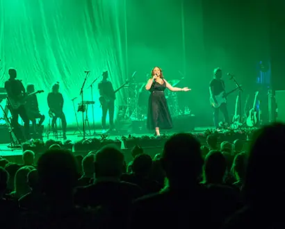 Artist sjunger från scen i grönt ljus